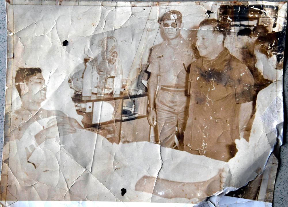 An old photo of 72-year-old retired Staff Sergeant Ahmad Ibrahim, from when he was visited by a military officer while receiving treatment at Kuching Hospital after surviving an attack by communists that left five other soldiers dead. - Bernama