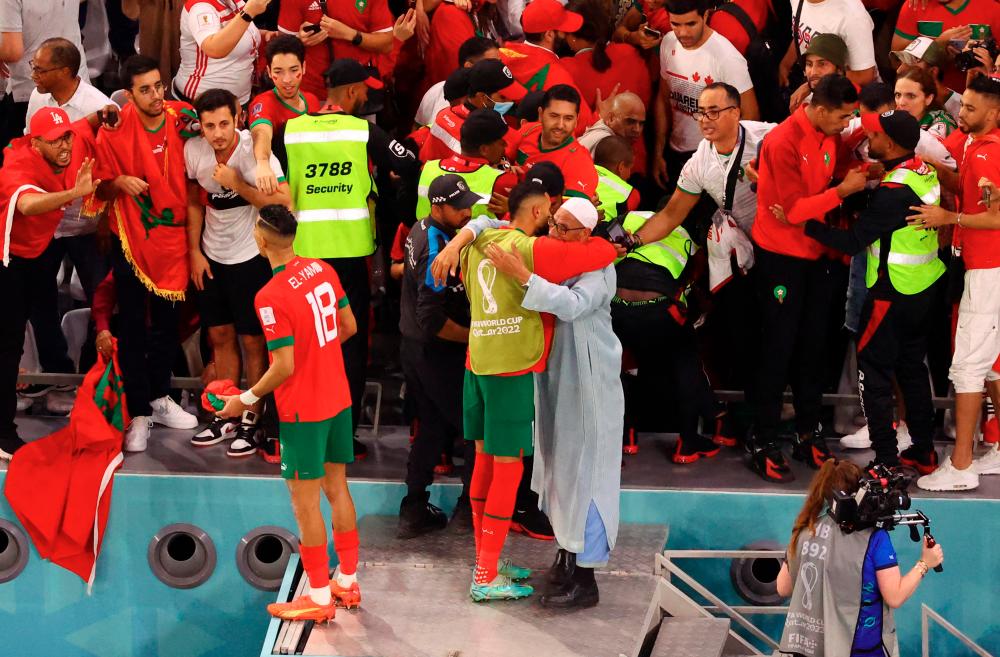 Morocco fans celebrate with Morocco's Jawad El Yamiq and a player after the match as Morocco qualify for the quarter finals/REUTERSPIX