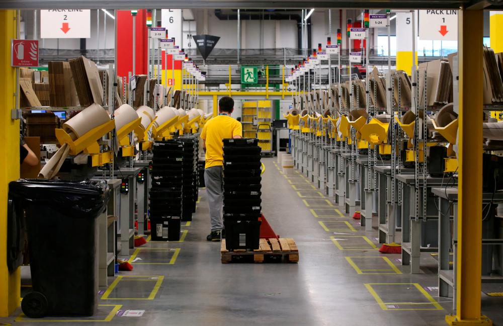 A worker moves boxes at a packaging area inside the Amazon distribution centre in El Prat de Llobregat, near Barcelona, Spain. – Reuterspic