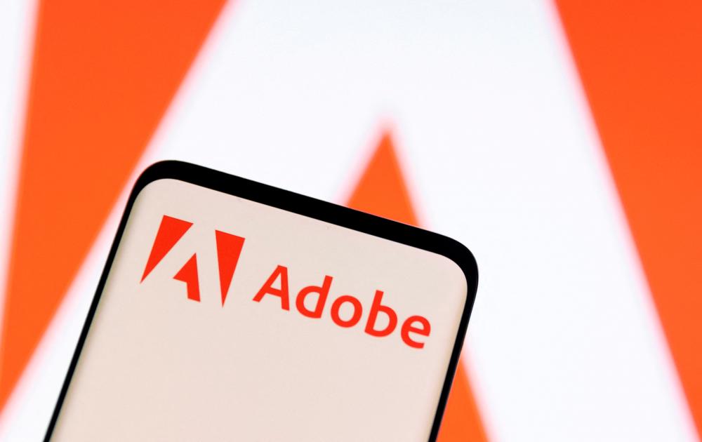 The Adobe logo is seen on a smartphone in this illustration photo. – Reuterspic