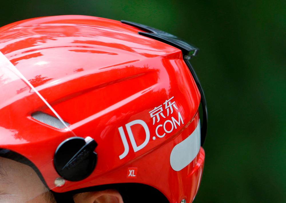 A logo of JD.com is seen on a helmet of a delivery man in Beijing. – Reuterspic