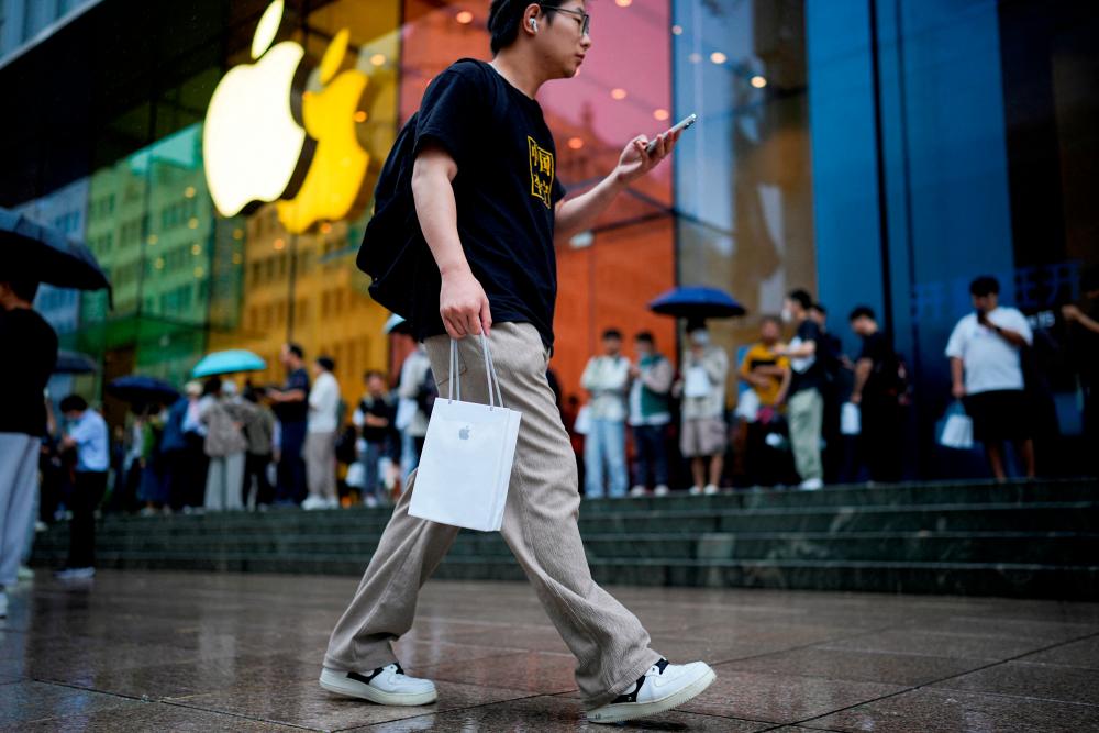 A man holds a bag with a new iPhone inside it in Shanghai, China. – Reuterspic