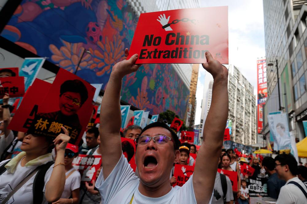 A demonstrator holds up a sign during a protest to demand authorities scrap a proposed extradition bill with China, in Hong Kong, China June 9, 2019. - Reuters
