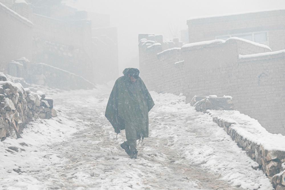 In this file photo taken on January 8, 2023, an Afghan man walks down a street during snowfall in Kabul. AFPPIX