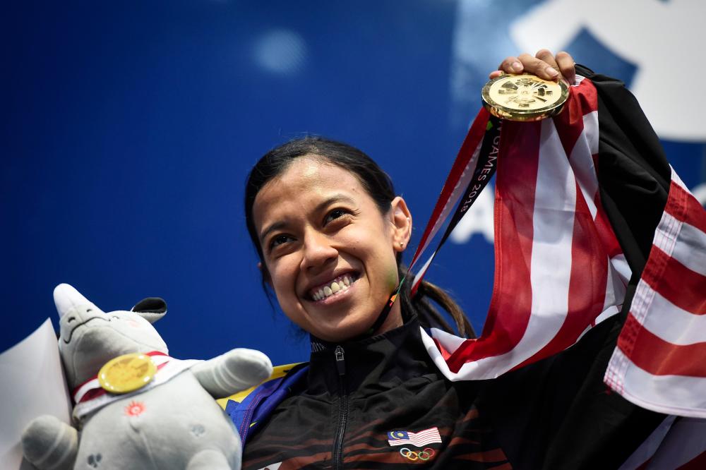 In this file photo taken on Aug 26, 2018 Malaysia's Nicol Ann David holds up her gold medal during the awards ceremony for the women's singles squash event at the 2018 Asian Games in Jakarta. — AFP