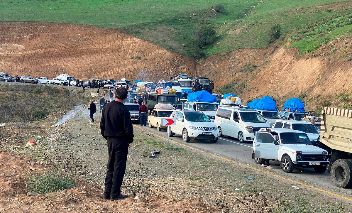 (FILES) Refugees drive their vehicules before crossing the border at Lachin district on September 28, 2023. - Siranush Sargsyan / AFP