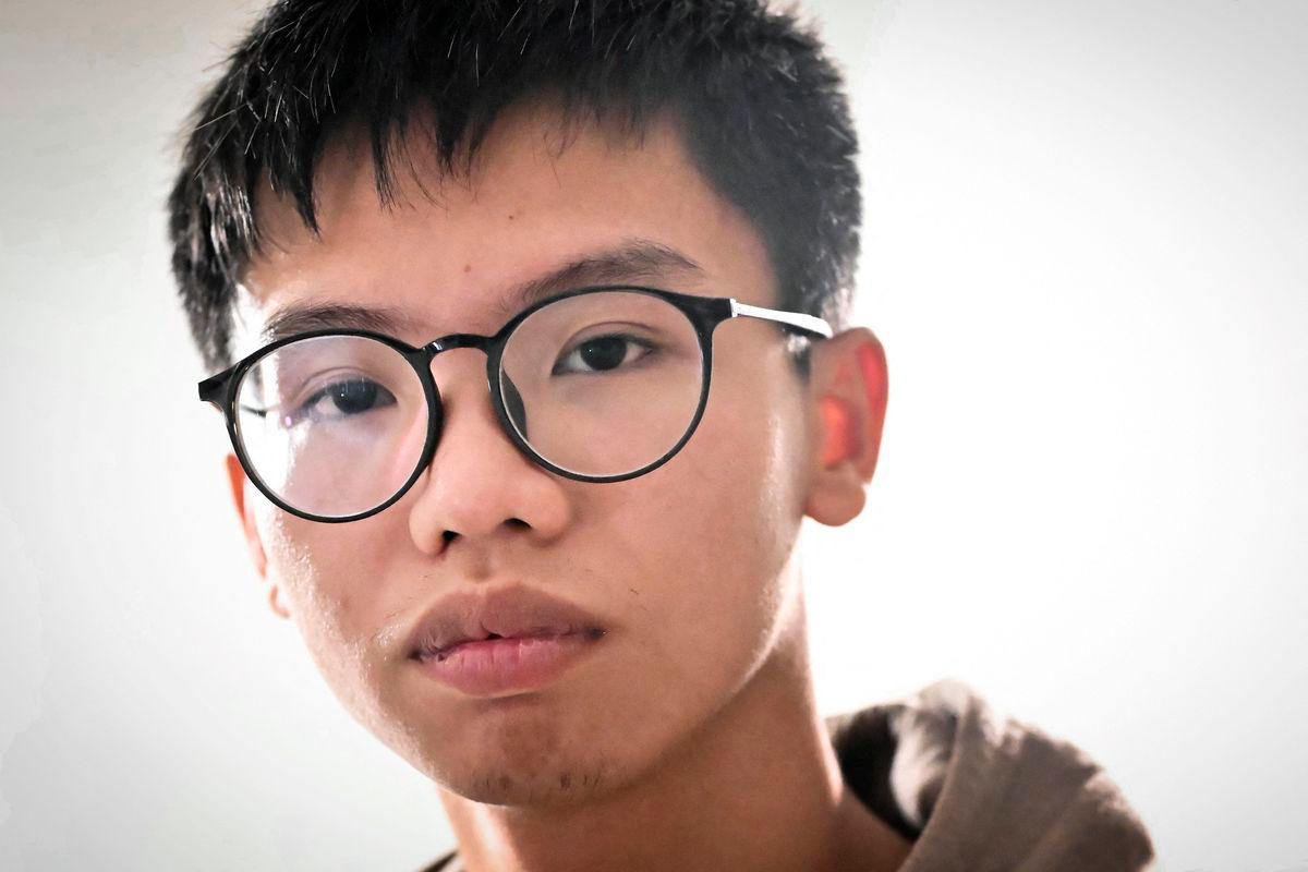 (FILES) Hong Kong democracy activist Tony Chung poses in a bedroom in Britain on December 29, 2023 after fleeing Hong Kong. Hong Kong democracy activist Tony Chung, who once called for the city’s independence and was the youngest person to be jailed under its national security law, announced on August 17, 2025 he has been granted asylum in the UK (Photo by Ben Stansall / AFP)