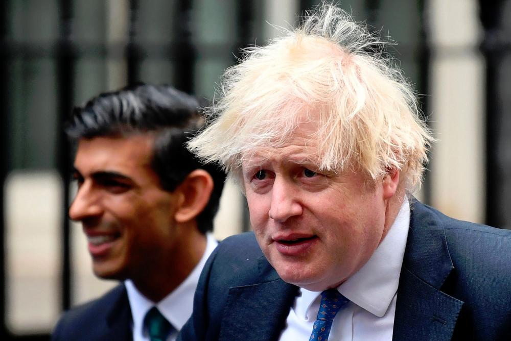 Britain’s Prime Minister Boris Johnson (R) stands with Britain’s Chancellor of the Exchequer Rishi Sunak during a meeting with Small Business Saturday entrepreneurs in Downing Street in central London. - AFPPIX