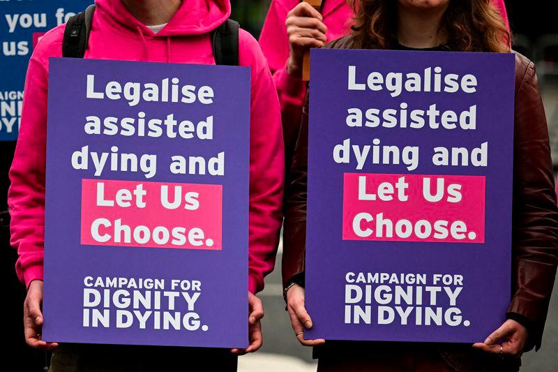 Campaigners from Dignity in Dying hold a placard during a demonstration outside The Palace of Westminster, home to the Houses of Parliament in central London, on October 16, 2024, during a gathering in favour of the proposal to legalise euthanasia in the UK. - AFPPIX