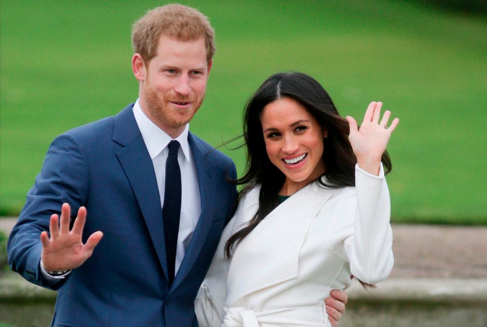 (FILES) In this file photo taken on November 27, 2017 Britain’s Prince Harry and his fiancée US actress Meghan Markle pose for a photograph in the Sunken Garden at Kensington Palace in west London following the announcement of their engagement. - AFP