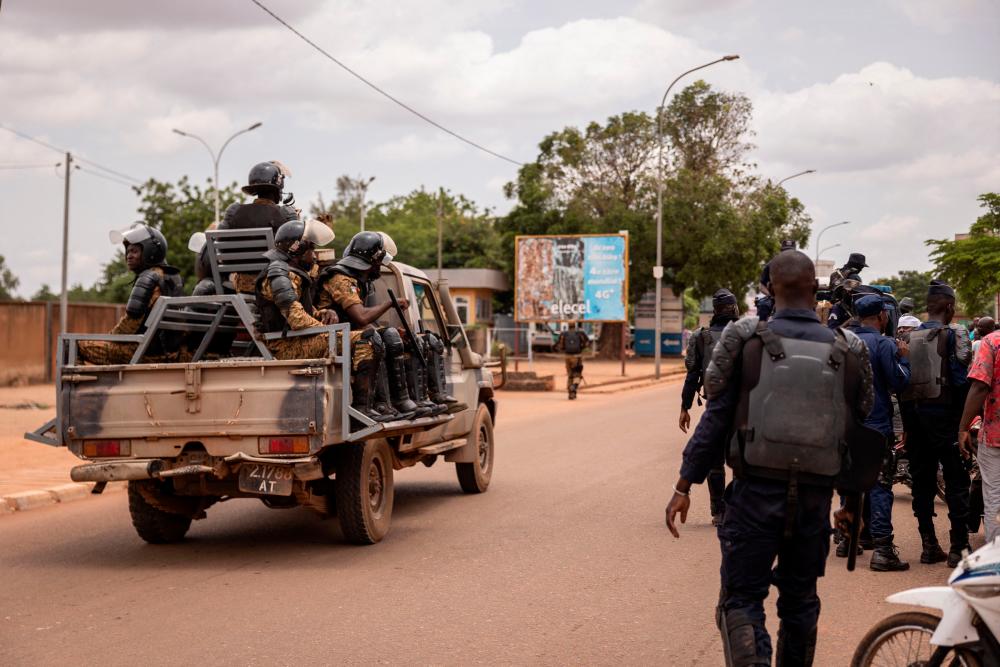 In this file photo taken on July 07, 2022 security forces drive on a vehicle near a crowd gathering awaiting the return of Blaise Compaore, former President of Burkina Faso, in front of Ouagadougou airport, 8 years after he was forced into exile in Ivory Coast in 2014. Shots were heard early Friday around Burkina Faso’s presidential palace and the headquarters of its military junta, which seized power in a coup last January, witnesses told AFP. AFPPIX
