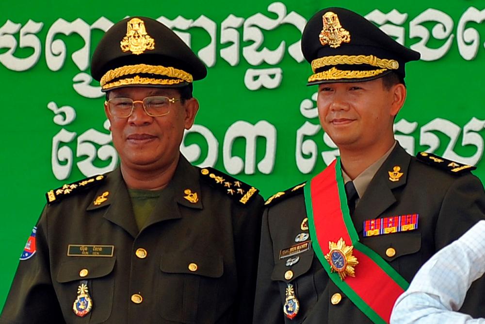 (FILES) In this file photo taken on October 13, 2009, Cambodia's Prime Minister Hun Sen (L) poses with his son Hun Manet during a ceremony at a military base in Phnom Penh. Cambodia's strongman Prime Minister Hun Sen, who has led the country for more than three decades, on December 2, 2021 backed his eldest son Hun Manet to take over the top job, paving the way for a political dynasty. AFPpix