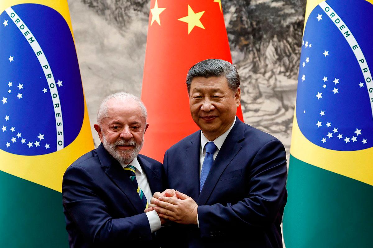 (FILES) Chinese President Xi Jinping (R) shakes hands with Brazil’s President Luiz Inacio Lula da Silva. - TINGSHU WANG / POOL / AFP