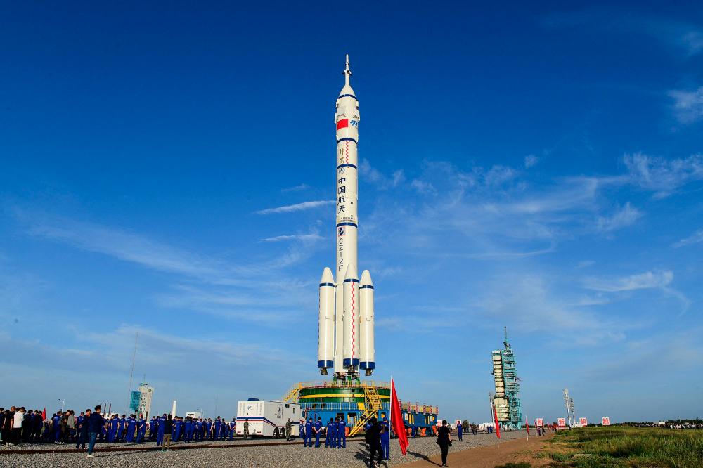 (FILES) This file photo taken on June 9, 2021 shows a Long March-2F carrier rocket carrying the Shenzhou-12 spacecraft for China's first manned mission to its new space station, scheduled for June 17, at the Jiuquan Satellite Launch Centre in the country's northwestern Gansu province. The first crew for China's new space station prepared to blast off on June 17, 2021 for the latest step in Beijing's ambitious programme to establish itself as a space power.– AFP