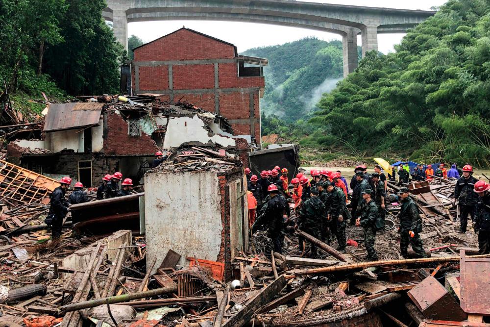 This file photo taken on August 11, 2019 shows rescuers and paramilitary police officers searching in the rubble of damaged buildings after torrential rain caused by Typhoon Lekima, at Yongjia, in Wenzhou, in China's eastern Zhejiang province. - AFP