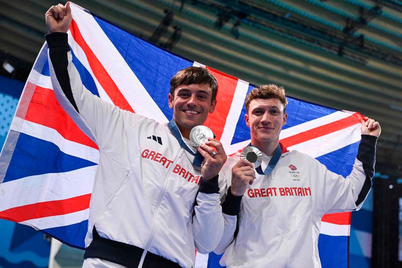 Silver medallists Britain’s Noah Williams (R) and Tom Daley celebrate with their medals following the men’s synchronised 10m platform diving at the Paris 2024 Olympic Games at the Aquatics Centre in Saint-Denis/AFPPIX