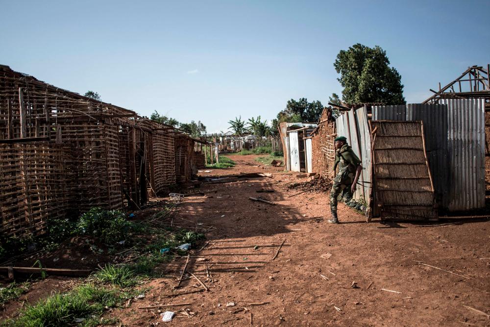 In this file photo taken on July 04, 2019 A soldier of the Armed Forces of the Democratic Republic of the Congo (FARDC) walks through a burned village/AFPPix