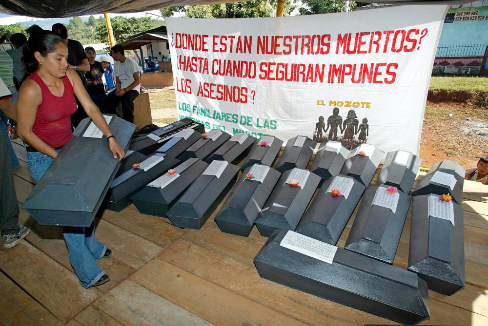 (FILES) In this file photo taken on December 13, 2003 a young woman carries the coffin containing the exhumed remains of a relative victim of the El Mozote slaughter, during a commemorative mass in El Mozote, 200km east of the capital San Salvador. AFPpix