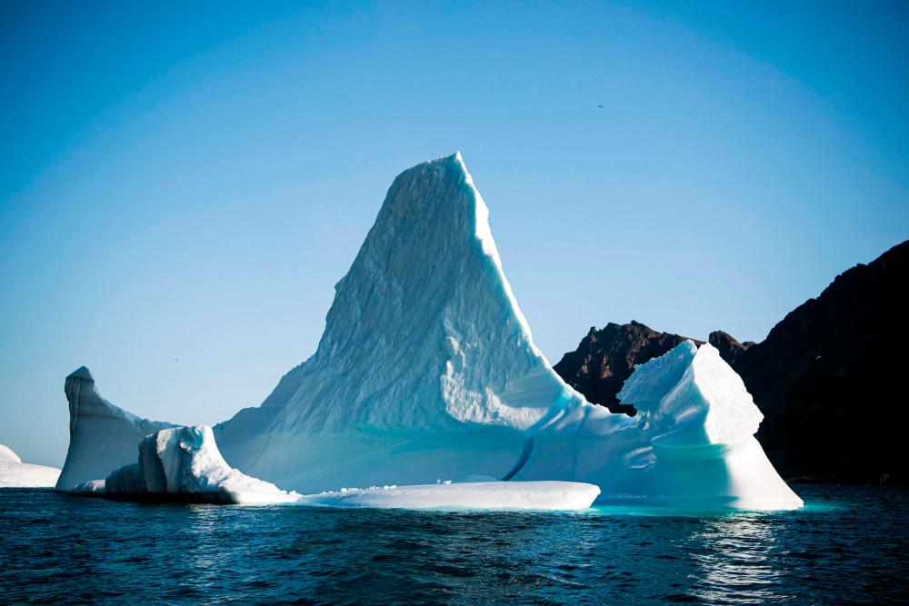 (FILES) In this file photo taken on August 17, 2019 an iceberg is pictured near the island of Kulusuk (also spelled Qulusuk), in the Sermersooq municipality on the southeastern shore of Greenland. – AFP