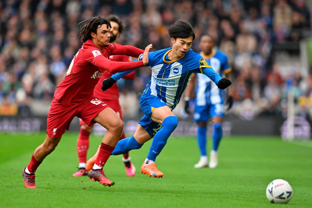Liverpool’s English defender Trent Alexander-Arnold (L) vies with Brighton’s Japanese midfielder Kaoru Mitoma (C) during the English FA Cup fourth round football match between Brighton &amp; Hove Albion and Liverpool at the Amex stadium in Brighton, on the south coast of England on January 29, 2023. AFPPIX