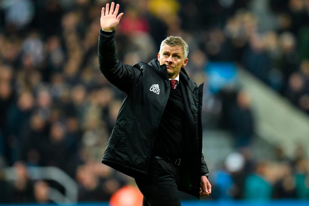 In this file photo taken on October 06, 2019 Manchester United's Norwegian manager Ole Gunnar Solskjaer gestures to supporters on the pitch after the English Premier League football match between Newcastle United and Manchester United at St James's Park in Newcastle-upon-Tyne, north east England on October 6, 2019. - AFP