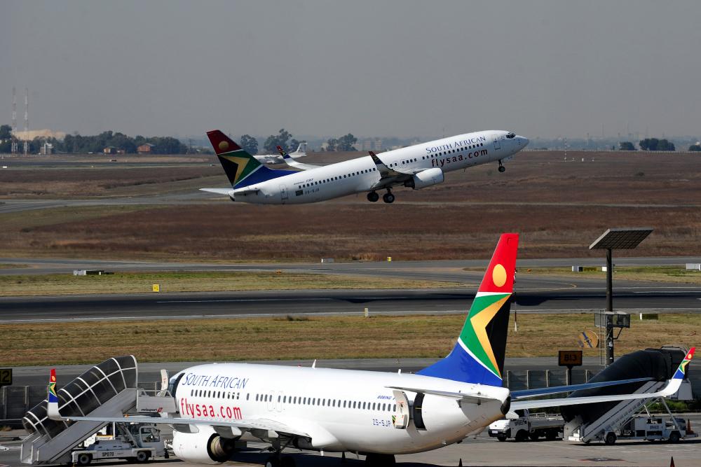 In this file photo taken on May 25, 2010, a South African airways flight takes off as another one is parked in a bay on the tarmac at the Johannesburg O.R Tambo International airport in Johannesburg, South Africa. — AFP