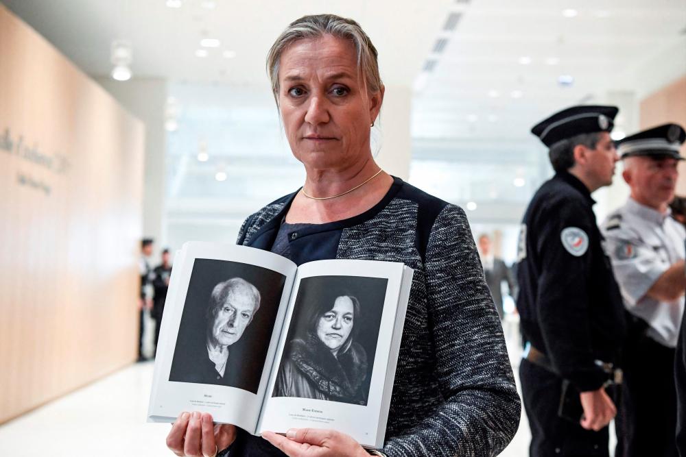 (FILES) In this file photo taken on September 23, 2019 French pulmonologist Irene Frachon poses with a photobook depicting portraits of “mediator victims” as she arrives at Paris’ courthouse before the start of the trial. - AFP