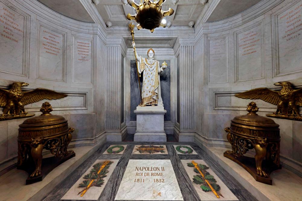(FILES) This file photo taken on April 07, 2021 shows the tomb Napoleon II, aka King of Rome, son of of French Emperor Napoleon I, with a Statue depicting Napoleon Bonaparte in full dress under the dome of the Hotel des Invalides, in Paris. The 200th anniversary of Napoleon Bonaparte's death will be marked on May 5, 2021. – AFP