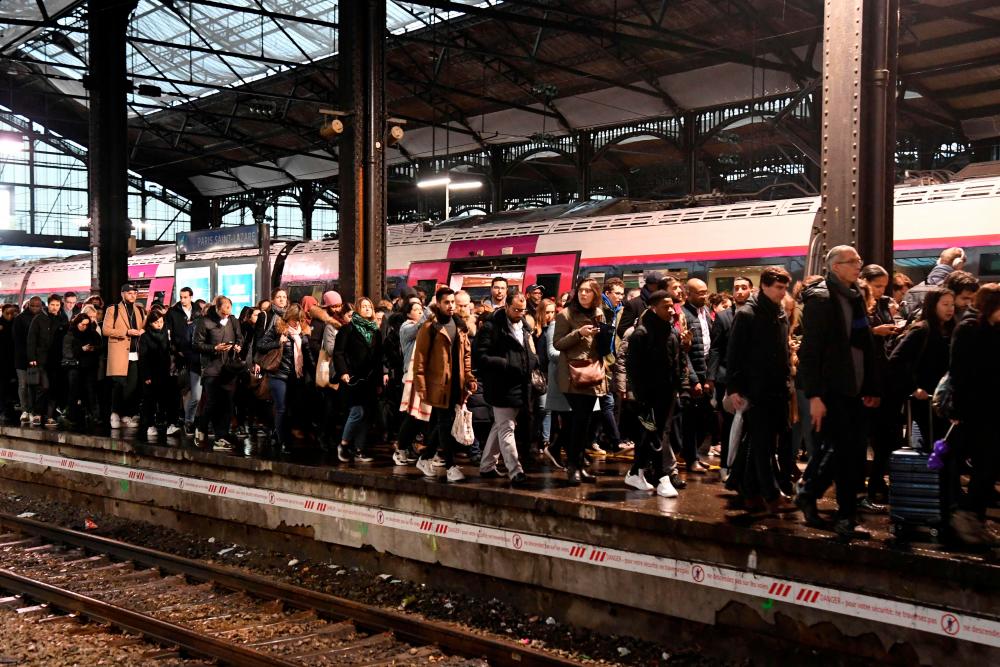 (FILES) In this file photo taken on December 16, 2019 commuters walk on a platform at the Gare Saint-Lazare train station in Paris, during a strike of Paris’ public transports operator RATP and of the French state railway company SNCF employees over French government’s plan to overhaul the country’s retirement system/AFPPix