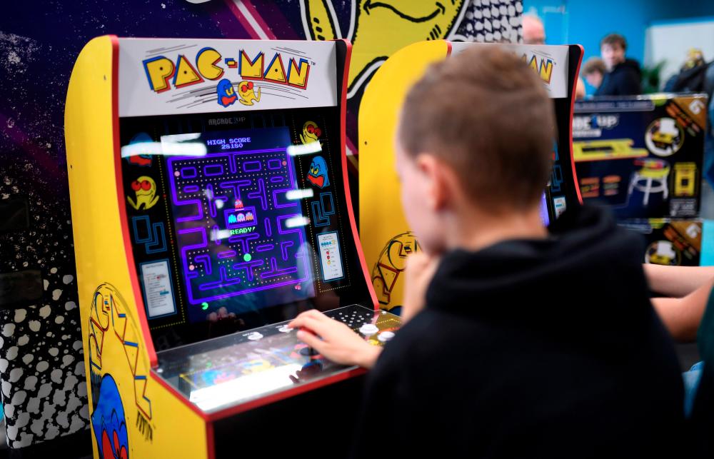 (FILES) This file photo taken on August 21, 2019 shows a boy playing the Pacman retro game at the video games trade fair Gamescom in the German city of Cologne. AFP / Ina FASSBENDER