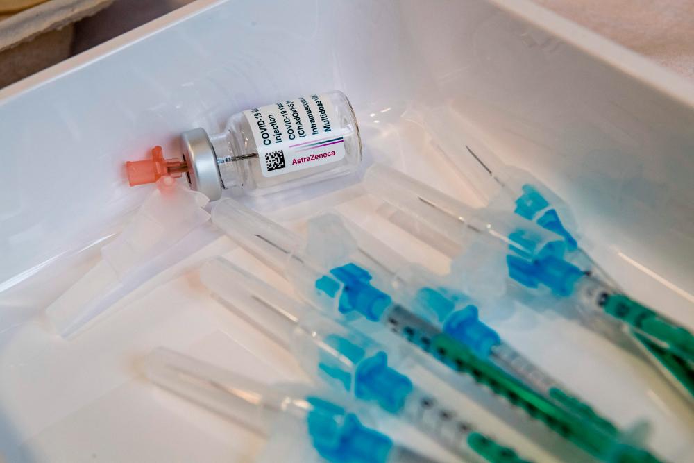 (FILES) In this file photo taken on February 12, 2021 an empty vial of the AstraZeneca Covid-19 vaccine and some syringes are seen on a tray at the university hospital in Halle/Saale, eastern Germany, at the start of the inoculation with the vaccine at the hospital. - AFP