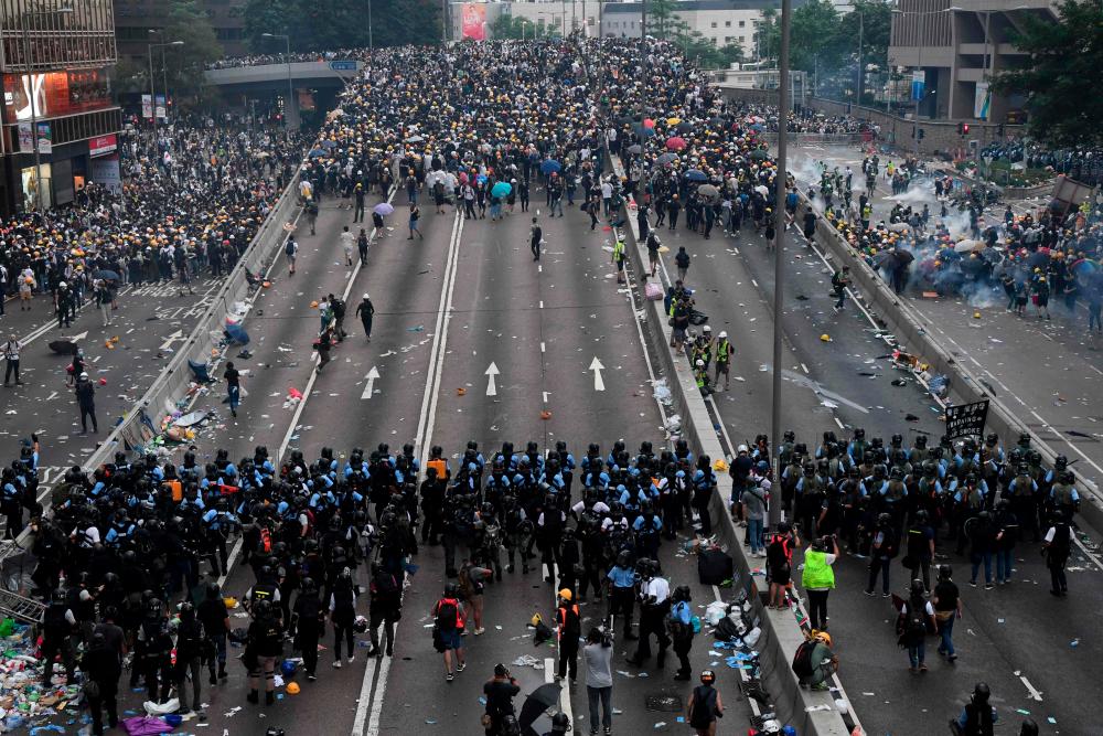 In this file photo taken on June 12, 2019, protesters face off with police after they fired tear gas during a rally against a controversial extradition law proposal outside the government headquarters in Hong Kong. — AFP