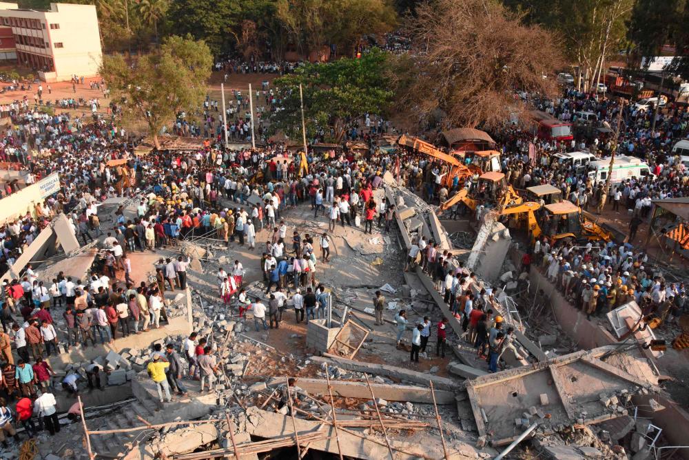 In this file photo taken on March 19, 2019, onlookers gather near the rubble while rescue team search for survivors after an under-construction multi-storey building collapsed in Dharwad district of Karnataka, situated about 700km north of Bangalore. — AFP