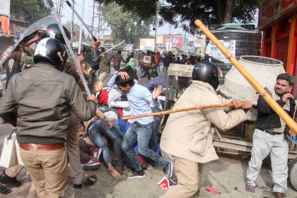 In this file picture taken on December 19, 2019, police with sticks locally known as lathi beat protesters during a demonstration against India's new citizenship law in Lucknow. - AFP