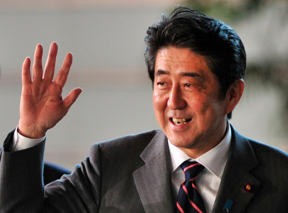 In this file photo taken on Dec 26, 2012, Shinzo Abe, elected by the parliament as Japan's prime minister, waves to the media upon his arrival at the prime minster's official residence in Tokyo. — AFP