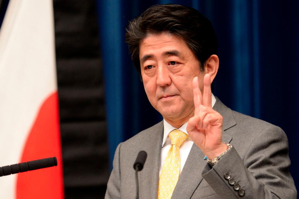 (FILES) This file photo taken on March 10, 2014 shows Japan's Prime Minister Shinzo Abe gesturing during a press conference for the upcoming anniversary of the March 11 quake-tsunami disaster, at his official residence in Tokyo. - AFPPIX