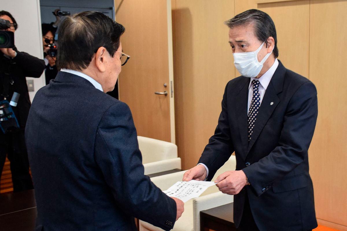 (FILES) This file photo taken on February 29, 2024 shows Mayor Hideo Kojima (R) handing over his resignation to chairman Akira Sakurai (L) in the town of Ginan, Gifu prefecture, after an official investigation accused Kojima of allegations of sexual harassment incidents.- Japan OUT (Photo by JIJI PRESS / AFP)