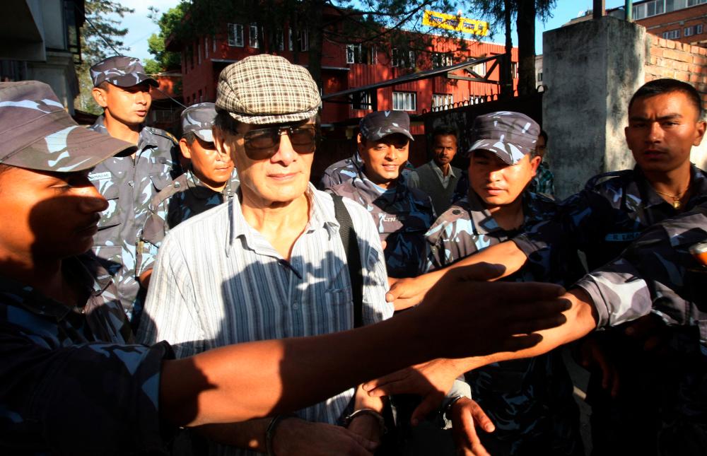 (FILES) In this file photo taken on June 01, 2011 French serial killer Charles Sobhraj (C) is guided by Nepalese policemen towards a waiting vehicle after a court hearing in Kathmandu on May 31, 2011/AFPPix