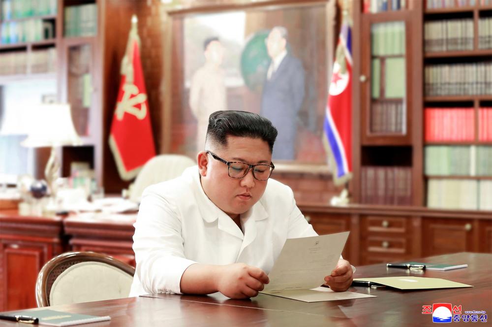 $!(FILES) This undated file picture released from North Korea’s official Korean Central News Agency (KCNA)on June 23, 2019 shows North Korean leader Kim Jong Un reading a personal letter from US President Donald Trump at an unknown location. AFP PHOTO/KCNA VIA KNS