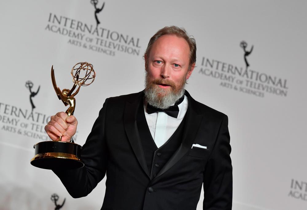 $!(FILES) This file photo taken on November 19, 2018 shows Danish actor Lars Mikkelsen holding his award for Best Performance by an Actor during the 46th International Emmy Awards gala in New York City. / AFP / Angela Weiss