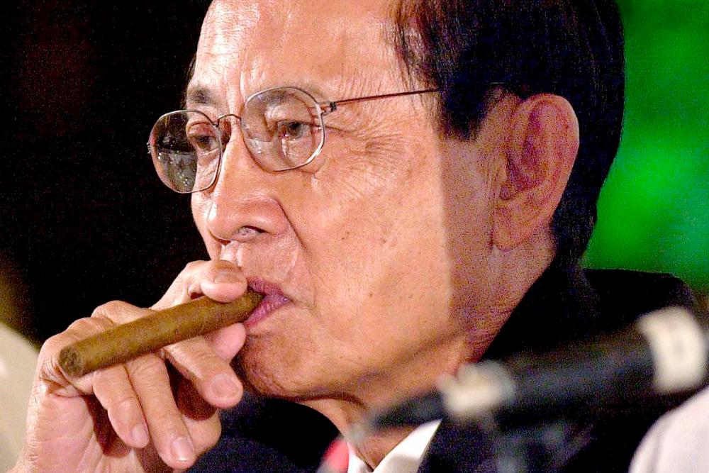 (FILES) This file photo taken on January 13, 2000 shows former president Fidel Ramos (L) puffing his cigar while President Joseph Estrada (not pictured) replies to journalist’s questions during a Foreign Correspondents Club forum in Manila. AFPPIX