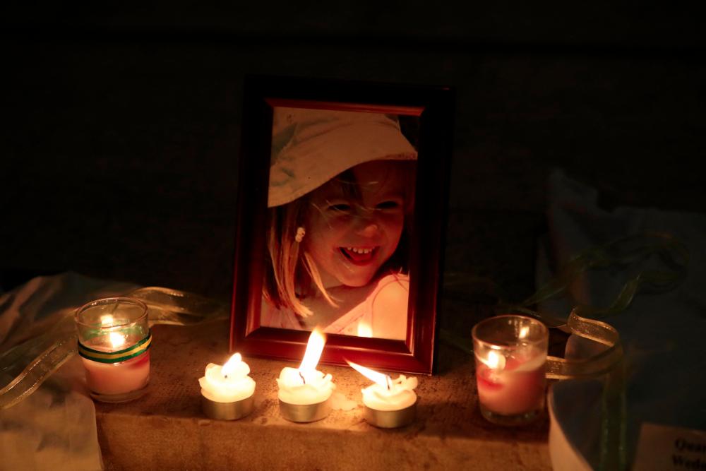 (FILES) In this file photo taken on May 3, 2017 candles have been placed in front of a photograph of Madeleine McCann inside the church of Praia da Luz, near Lagos, Portugal, during a mass ceremony marking the 10th anniversairy of her disappearance. - AFPPIX