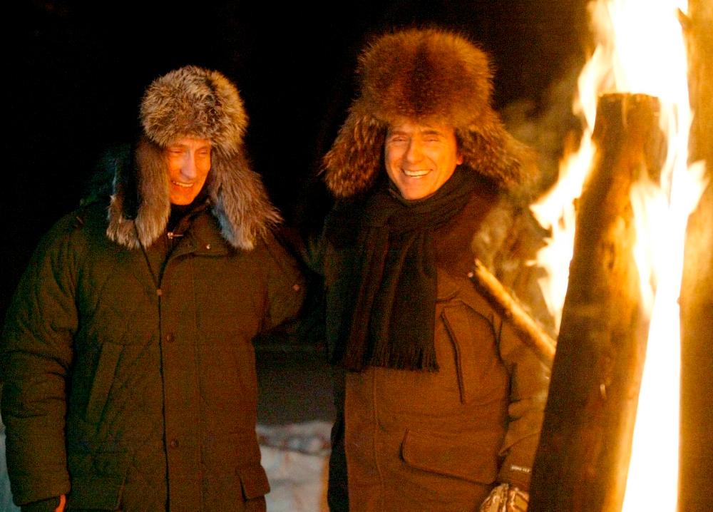 Russian President Vladimir Putin (L) and Italian Prime Minister Silvio Berlusconi (R) smile as they stand near a huge fire in a wildlife preserve and recreation area near a residence of Zavidovo some 120 km north-west of Moscow, 03 February 2003. AFPPIX