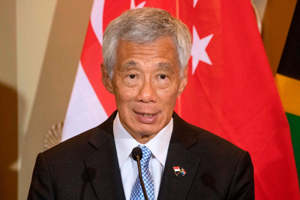 (FILES) Singapore's Prime Minister Lee Hsien Loong speaks at a press conference during his visit at the South African Parliament in Cape Town on May 16, 2023. Singapore Prime Minister Lee Hsien Loong, who has been in office since 2004, announced on November 5, 2023 he will hand over power to the current finance minister Lawrence Wong, 50, before the 2025 general elections. - AFPPIX