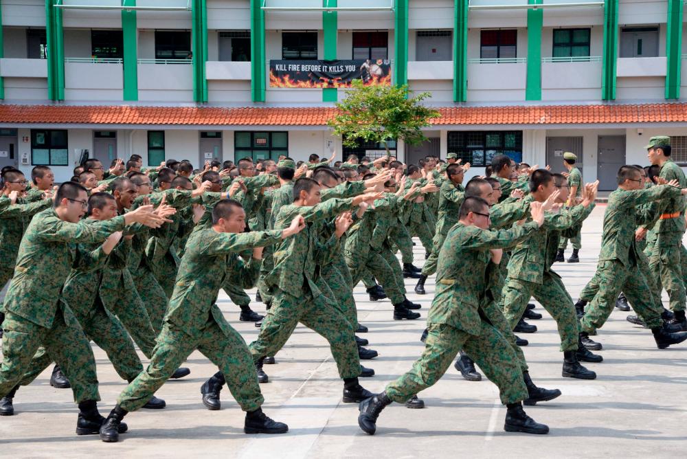 (FILES) In this file photo taken on February 7, 2017 National Service recruits demonstrate hand-to-hand combat moves as part of their two-month basic training on Pulau Tekong off Singapore. AFPpix