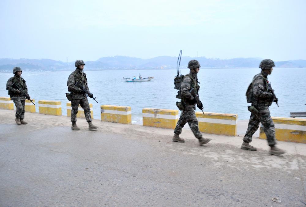 In this file photo taken on April 14, 2013, South Korean soldiers patrol on the South Korea-controlled island of Yeonpyeong near the disputed waters of the Yellow Sea at dawn. — AFP