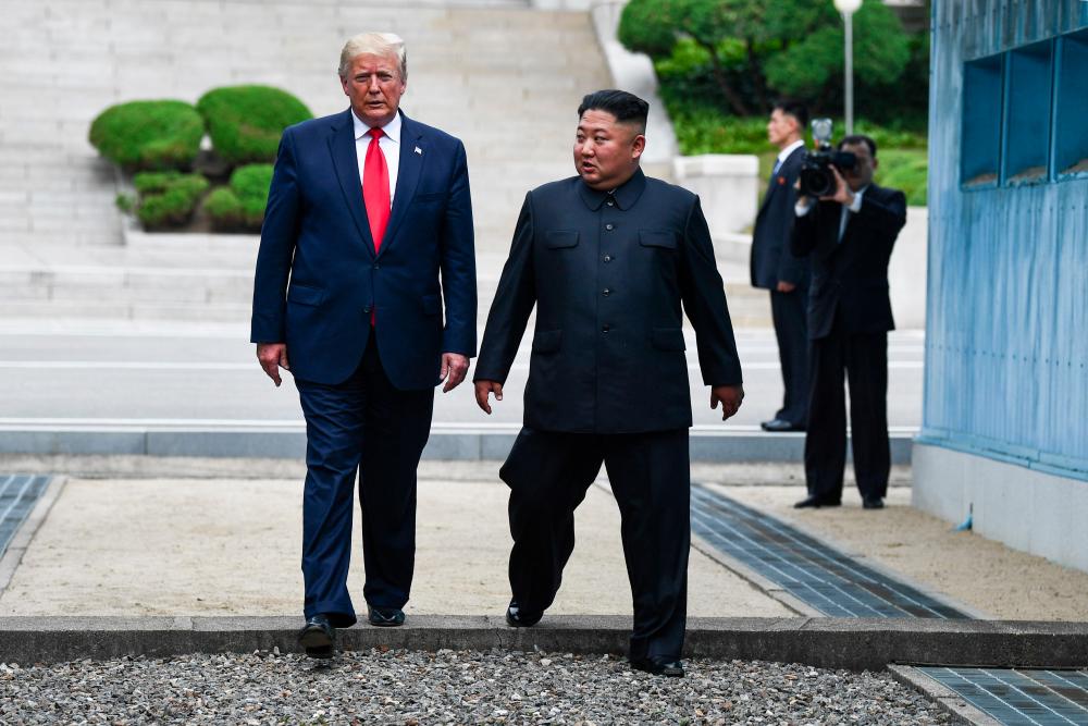 In this file photo taken on June 30, North Korea's leader Kim Jong Un and US President Donald Trump cross south of the Military Demarcation Line that divides North and South Korea, after Trump briefly stepped over to the northern side, in the Joint Security Area (JSA) of Panmunjom in the Demilitarised zone (DMZ). — AFP