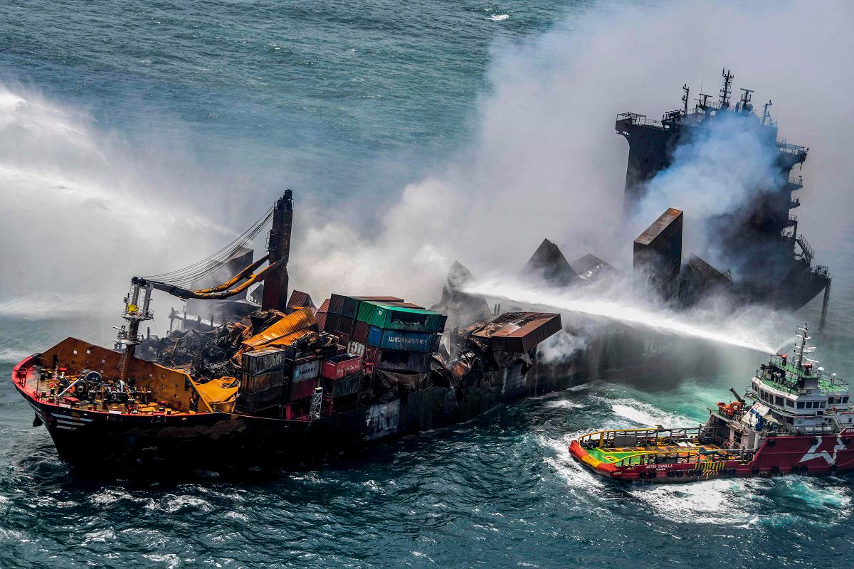 (FILES) This handout photograph taken and released by the Sri Lanka Air Force on May 30, 2021 shows smoke billowing from the Singapore-registered container ship MV X-Press Pearl, which has been burning for the eleventh consecutive day as vessels try to douse off the fire, in the sea off Sri Lanka’s Colombo Harbour, in Colombo. - SRI LANKA AIR FORCE / AFP