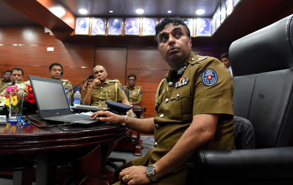 In this file photo taken on March 07, 2017, Sri Lanka police chief Pujith Jayasundara (R) launches the first on-line service delivery of the Sri Lankan police at the headquarters in Colombo. Sri Lanka's President on April 29 suspended his police chief over his alleged failure to prevent Easter Sunday suicide bombings that killed 253 people and named a successor to lead investigations. — AFP