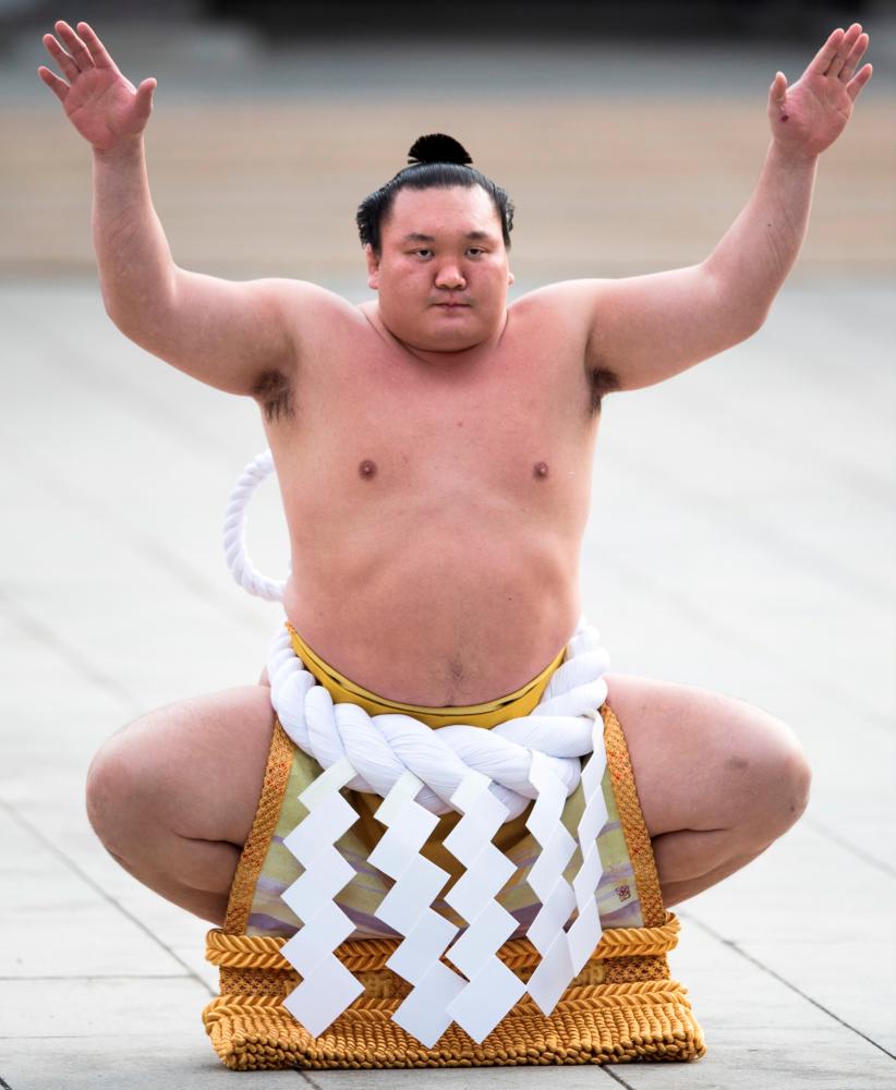 (FILES) This file photo taken on January 6, 2017 shows Mongolian-born sumo grand champion or “yokozuna” Hakuho performing a ring-entering ceremony at Meiji Shrine in Tokyo. Record-breaking sumo champion Hakuho has tested positive for the COVID-19 coronavirus, just days before the New Year tournament, the Japan Sumo Association said on January 5, 2021. AFP / Behrouz MEHRI